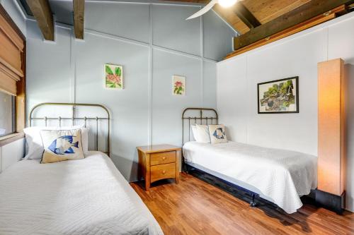 two beds in a room with white walls and wooden floors at Mauna Kai 8 in Princeville