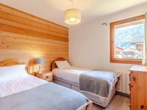 une chambre avec deux lits et une fenêtre dans l'établissement Charmant T4 à Morzine, proche centre et remontées, idéal pour 8 pers., garage inclus - FR-1-754-13, à Morzine