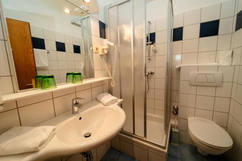 ein Bad mit einem Waschbecken, einer Dusche und einem WC in der Unterkunft Metzgerwirt in Radenthein