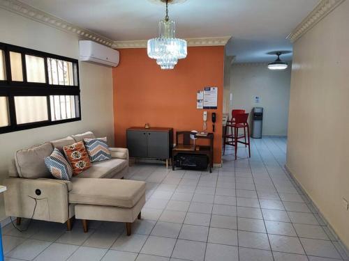een woonkamer met een bank en een tv bij Bella Vista Apartment, Oasis Residential in Santo Domingo