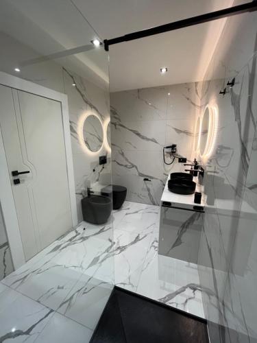 uma casa de banho com paredes em mármore branco e uma bancada. em Suites - ghibellina 92 em Florença