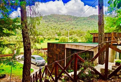 a car parked in front of a house with trees at Loft37 - Íntimo / Inmerso en la naturaleza in San Cristóbal de Las Casas