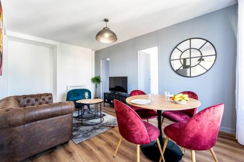 un soggiorno con divano, tavolo e sedie di Esprit Marvel: 2 chambres- fibre- balcon- parking a Grenoble