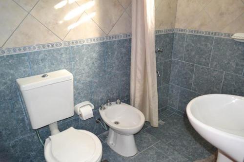 Un baño con un inodoro blanco y un lavabo. en Complejo El Ensueño, en Colón