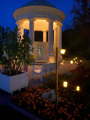 a gazebo with a bench in a garden at night at Schickes Studio in bester Lage in Bad Salzuflen