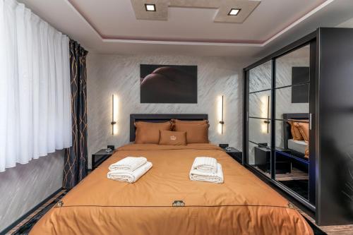 1 dormitorio con 1 cama grande y toallas. en Lotus Wellness & spa apartman, en Koprivnica