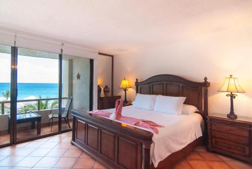 a bedroom with a bed and a view of the ocean at Solymar Condo Beach Resort by Casago in Canc&uacute;n
