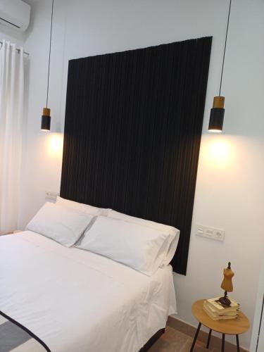 Colon 13 في سمورة: غرفة نوم مع سرير أبيض مع اللوح الأمامي الأسود