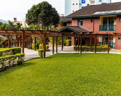 a building with a green lawn in front of a building at Spazio Vital Apartments in Florianópolis