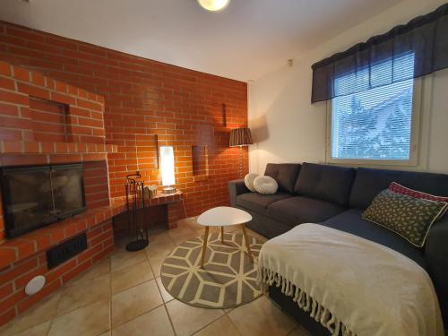 a living room with a couch and a brick wall at Nord Riverside in Rovaniemi