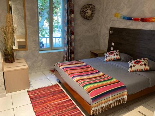 um quarto com uma cama com um cobertor colorido em Appartement « Mexico », Avignon em Avignon