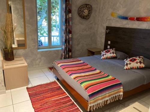 - une chambre avec un lit et une couverture colorée dans l'établissement Appartement « Mexico », Avignon, à Avignon