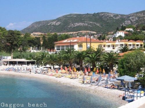 a beach with a bunch of chairs and palm trees at STUDIO ILIANA in Samos