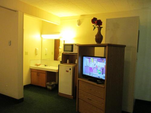 Habitación de hotel con TV y cocina en Townhouse Motel, en Longview