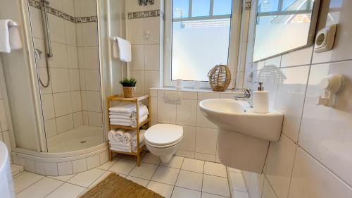 a bathroom with a sink and a toilet and a shower at Haus Eversand Nr 2 in Cuxhaven