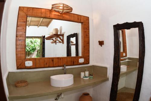 y baño con lavabo y espejo. en Pousada Coco Brasil, en Caraíva