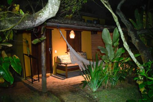 una hamaca frente a una casa por la noche en Pousada Coco Brasil, en Caraíva