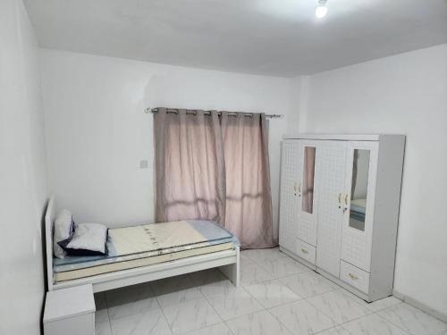 Habitación pequeña con cama y ventana en Abu Dhabi Tourist Club-Hotel Home Stay, en Abu Dabi
