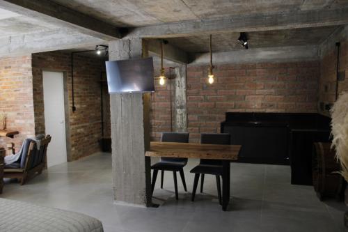 a dining room with a wooden table and a piano at Pietra Rossa- Vale dos Vinhedos in Bento Gonçalves