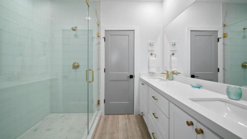 een badkamer met een glazen douche en een wastafel bij Uncharted in Galveston