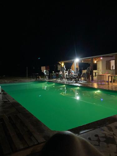 - une piscine avec des personnes debout la nuit dans l'établissement Sitio Aconchego, à Mariana