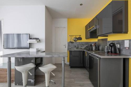 une cuisine avec une table et deux tabourets blancs dans l'établissement 600m Gare et 400m Gem: lit double, wifi fibre, à Grenoble