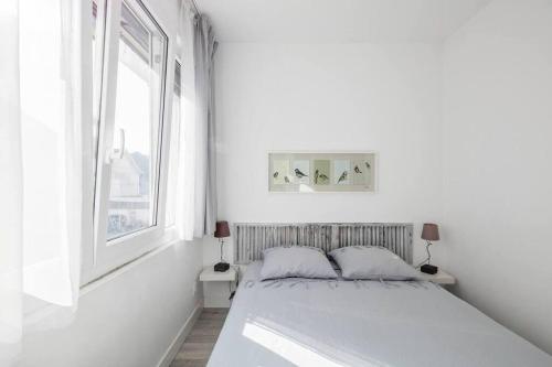 une chambre blanche avec un lit et une fenêtre dans l'établissement 600m Gare et 400m Gem: lit double, wifi fibre, à Grenoble