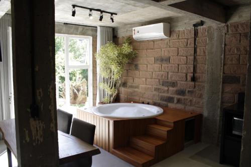 a bathroom with a large tub and a window at Pietra Rossa- Vale dos Vinhedos in Bento Gonçalves