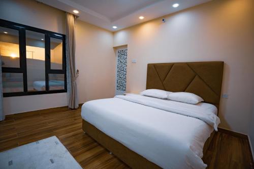 Un dormitorio con una cama grande y una ventana en استراحة الكثبان, en Ḩawīyah