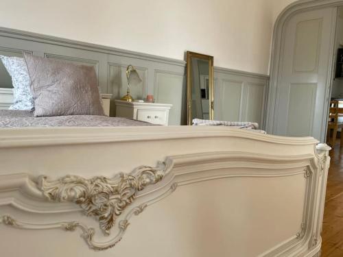 1 dormitorio con 1 cama blanca grande y espejo en Schloss Hürbel Storchennest-Appartement - Luxury Apartment THE Stork Nest, en Gutenzell-Hürbel