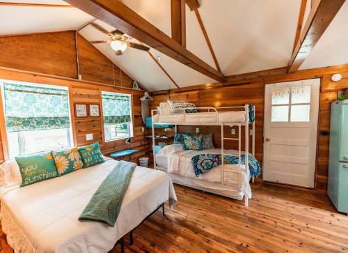 2 Etagenbetten in einem Zimmer mit Holzwänden in der Unterkunft Big Blue Lake Cottages, LLC - Cottage #5 in Holton