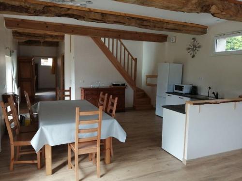 une cuisine et une salle à manger avec une table et des chaises dans l'établissement Les écuries du Mesnil aux Moines, à Osmoy-Saint-Valery