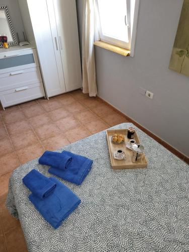 um quarto com uma mesa com toalhas azuis e uma bandeja de comida em Apartamento Sol em La Vegueta