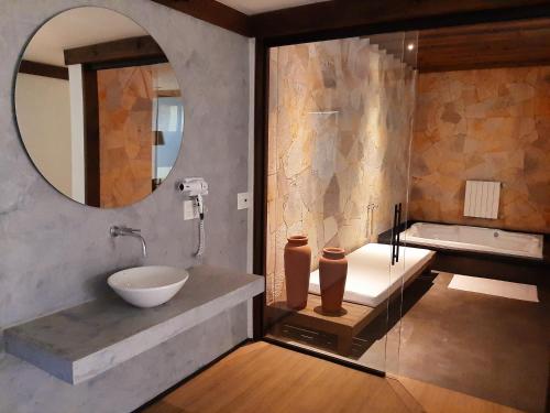 een badkamer met een wastafel, een spiegel en een bad bij LUV Gardens Motel - Adults Only in Caxias do Sul