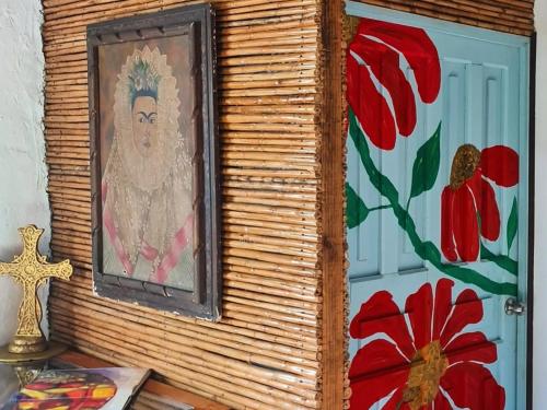 una pintura en una pared con flores rojas en Cabañas Mannan, en Tanchachín