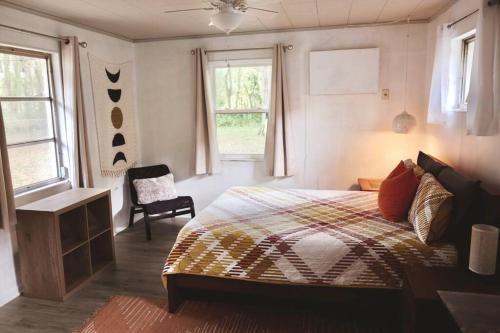 - une chambre avec un lit, une chaise et des fenêtres dans l'établissement 3BR Downtown House with Yard by UF, à Gainesville