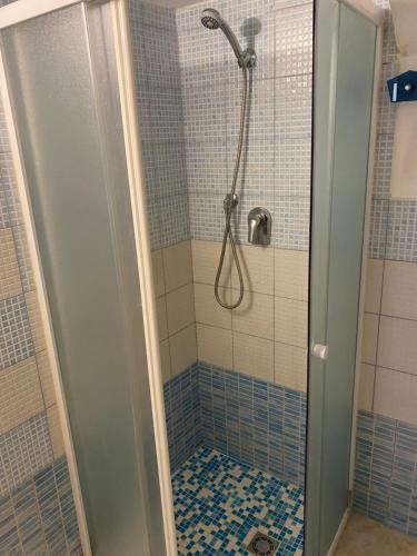 y baño con ducha y azulejos azules y blancos. en Dory’s House, en Ragusa