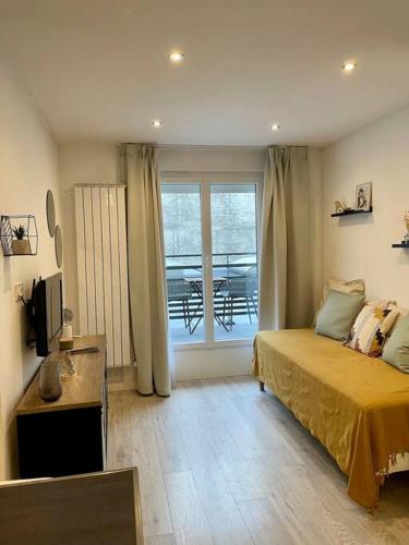 une chambre avec un lit et un balcon avec une table dans l'établissement Proche Gare et Gem: tout équipé,wifi fibre, balcon, à Grenoble