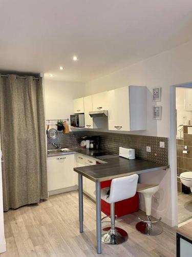 une cuisine avec une table et des chaises dans une pièce dans l'établissement Proche Gare et Gem: tout équipé,wifi fibre, balcon, à Grenoble