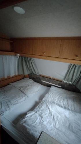 una cama en la parte trasera de una habitación en Wildcamp Resort Masseria la Murgia Unterkunft in einem Wohnwagen, en Rimbach