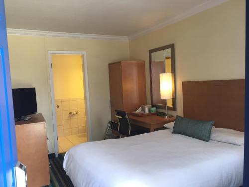 a hotel room with a bed and a desk and a bathroom at Surf Motel in San Francisco