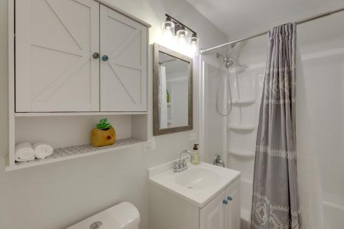 een witte badkamer met een wastafel en een spiegel bij Grand Junction Home with Deck about 2 Mi to Downtown! in Grand Junction