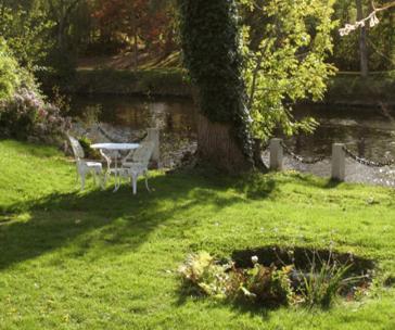 a table and chairs in a yard with a tree at Hotel Lilton in Ängelholm