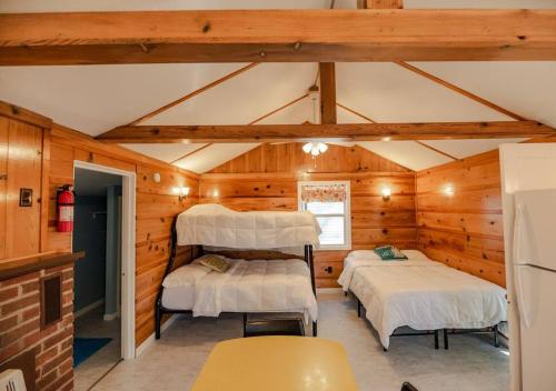 una camera con due letti in una cabina di legno di Big Blue Lake Cottages, LLC - Cottage #3 a Holton