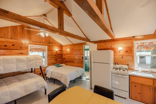 una cucina con 2 letti e un frigorifero in una camera di Big Blue Lake Cottages, LLC - Cottage #3 a Holton