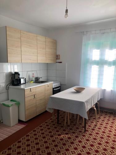 eine Küche mit einem Tisch, einem Tisch und einem Tisch sowie einer Küche in der Unterkunft Pridvorul lui Viorel in Proviţa de Sus