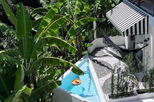 a swimming pool with a hammock next to some plants at CasaIvan in Florianópolis