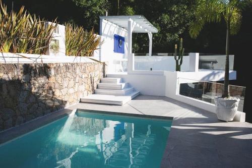 a swimming pool with stairs and a white house at CasaIvan in Florianópolis