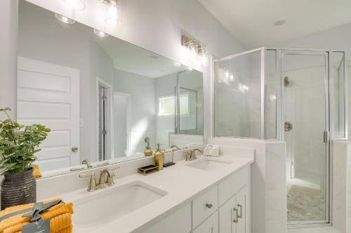 a white bathroom with two sinks and a shower at Sunny Memphis Home about 2 Mi to Beale Street! in Memphis