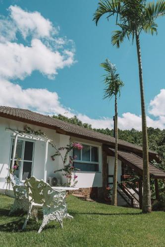 a house with a palm tree and a chair in the yard at CasaIvan in Florianópolis